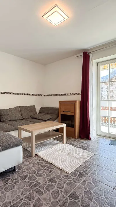 Sandro Anibas sitzt in einer luxuriösen Wohnung und schaut lächelnt von einer Zeitschrift auf