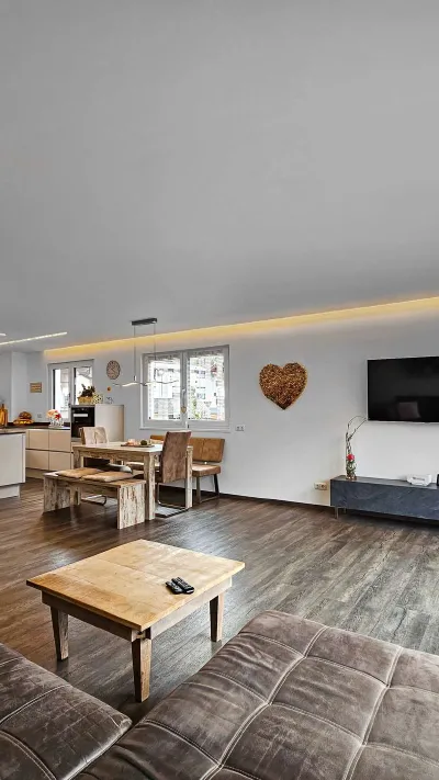Sandro Anibas sitzt in einer luxuriösen Wohnung und schaut lächelnt von einer Zeitschrift auf
