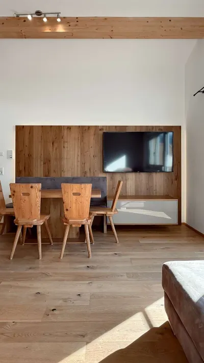 Sandro Anibas sitzt in einer luxuriösen Wohnung und schaut lächelnt von einer Zeitschrift auf