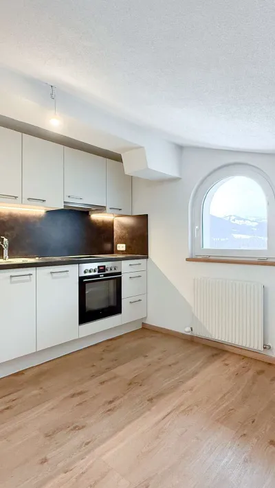 Sandro Anibas sitzt in einer luxuriösen Wohnung und schaut lächelnt von einer Zeitschrift auf