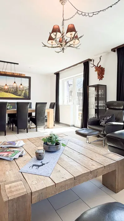 Sandro Anibas sitzt in einer luxuriösen Wohnung und schaut lächelnt von einer Zeitschrift auf