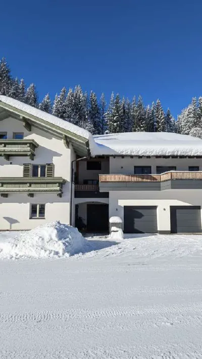 Sandro Anibas sitzt in einer luxuriösen Wohnung und schaut lächelnt von einer Zeitschrift auf