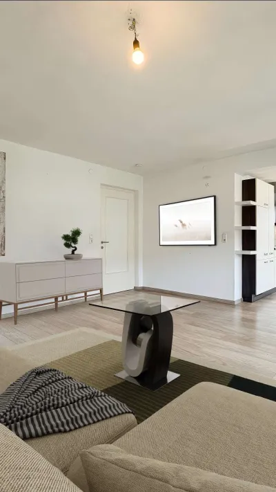 Sandro Anibas sitzt in einer luxuriösen Wohnung und schaut lächelnt von einer Zeitschrift auf
