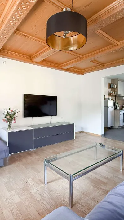 Sandro Anibas sitzt in einer luxuriösen Wohnung und schaut lächelnt von einer Zeitschrift auf