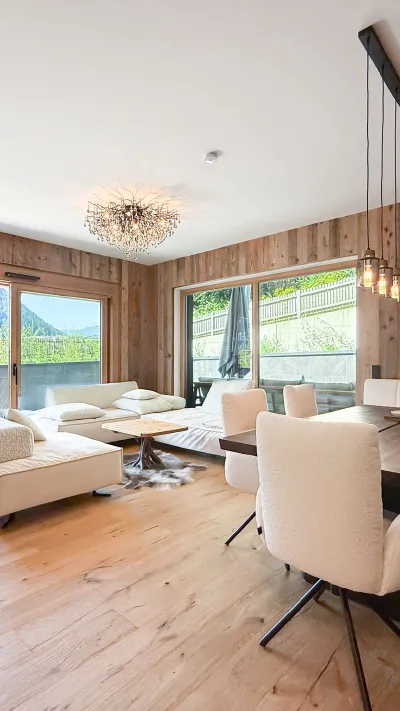 Sandro Anibas sitzt in einer luxuriösen Wohnung und schaut lächelnt von einer Zeitschrift auf