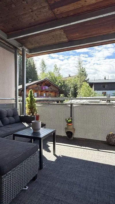 Sandro Anibas sitzt in einer luxuriösen Wohnung und schaut lächelnt von einer Zeitschrift auf