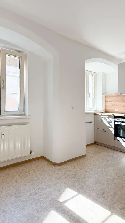 Sandro Anibas sitzt in einer luxuriösen Wohnung und schaut lächelnt von einer Zeitschrift auf