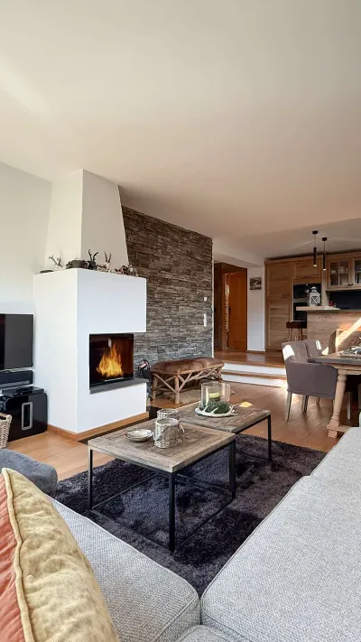 Sandro Anibas sitzt in einer luxuriösen Wohnung und schaut lächelnt von einer Zeitschrift auf