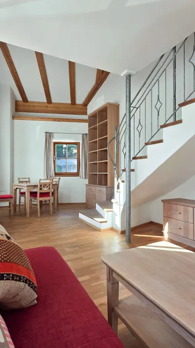 Sandro Anibas sitzt in einer luxuriösen Wohnung und schaut lächelnt von einer Zeitschrift auf