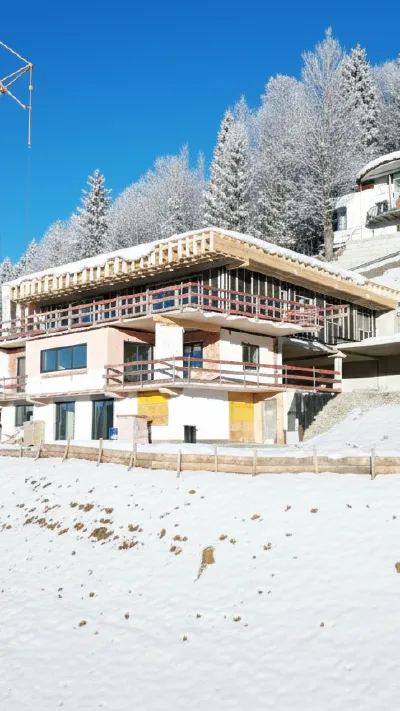 Sandro Anibas sitzt in einer luxuriösen Wohnung und schaut lächelnt von einer Zeitschrift auf