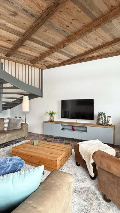 Sandro Anibas sitzt in einer luxuriösen Wohnung und schaut lächelnt von einer Zeitschrift auf