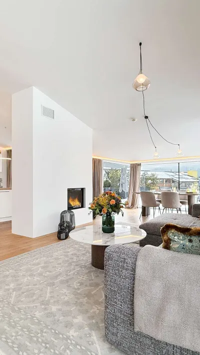 Sandro Anibas sitzt in einer luxuriösen Wohnung und schaut lächelnt von einer Zeitschrift auf