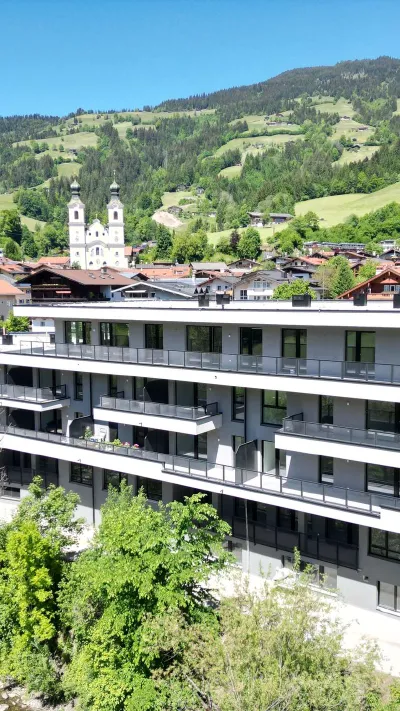 Sandro Anibas sitzt in einer luxuriösen Wohnung und schaut lächelnt von einer Zeitschrift auf