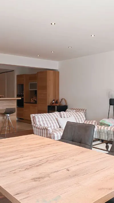 Sandro Anibas sitzt in einer luxuriösen Wohnung und schaut lächelnt von einer Zeitschrift auf