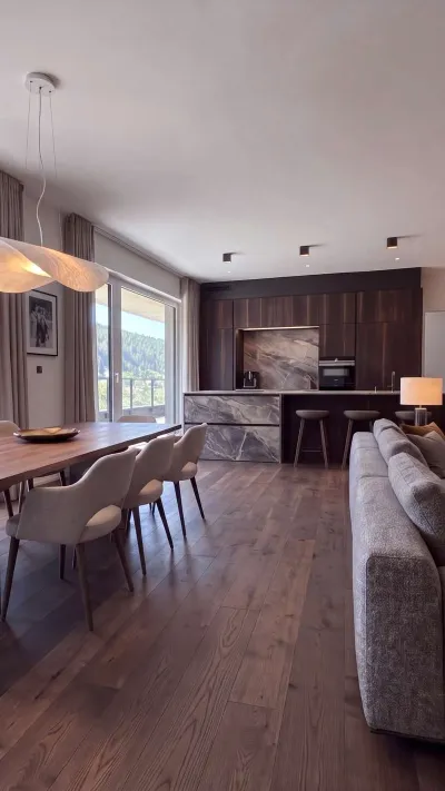 Sandro Anibas sitzt in einer luxuriösen Wohnung und schaut lächelnt von einer Zeitschrift auf
